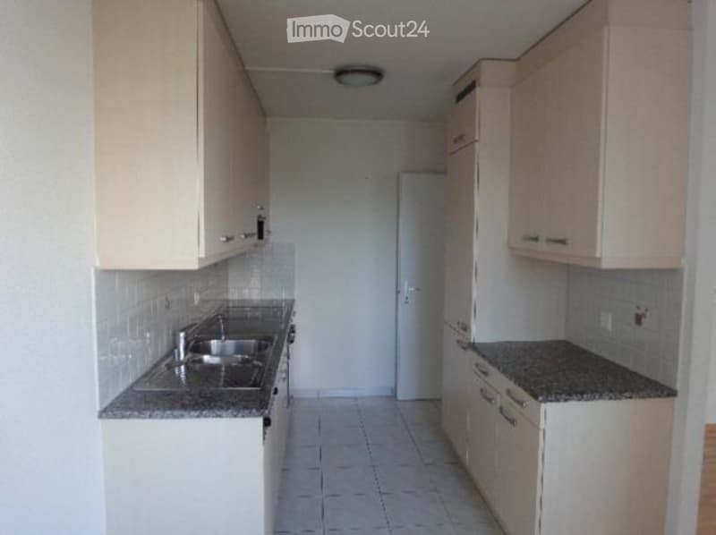 Empty kitchen with cabinets, granite countertop, sink, and ceiling light