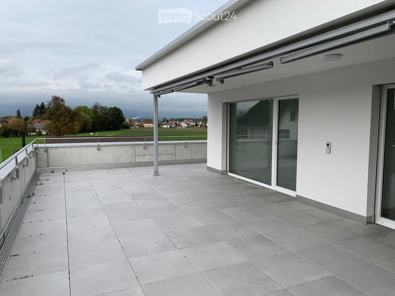 tiled balcony, railing, modern white building, glass door, landscape view, gray sky