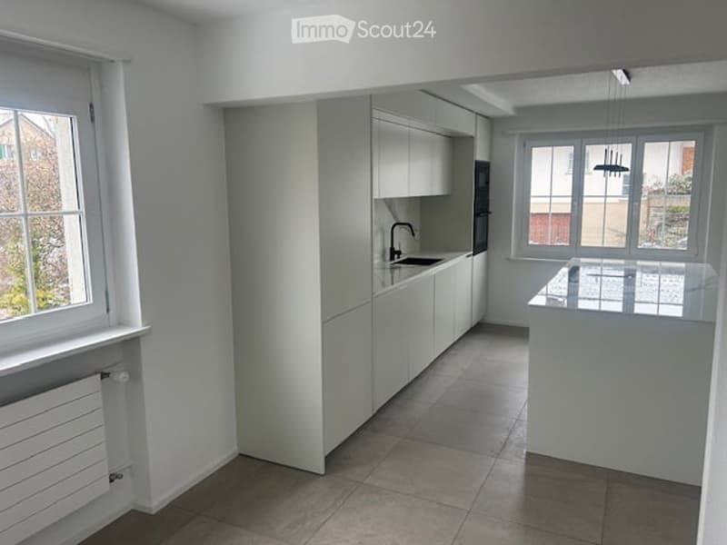 modern kitchen with white cabinets, tiled floor, under-mount sink, pendant light, microwave, refrigerator, windows