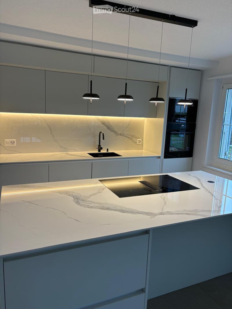 modern kitchen with marble countertops, white cabinets, black induction hob, modern faucet, black double oven