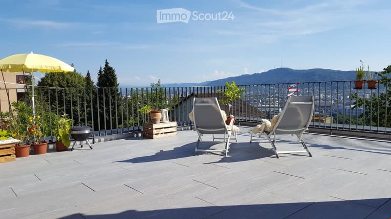 Balcony with lounge chairs, umbrella, potted plants, and a scenic city view.