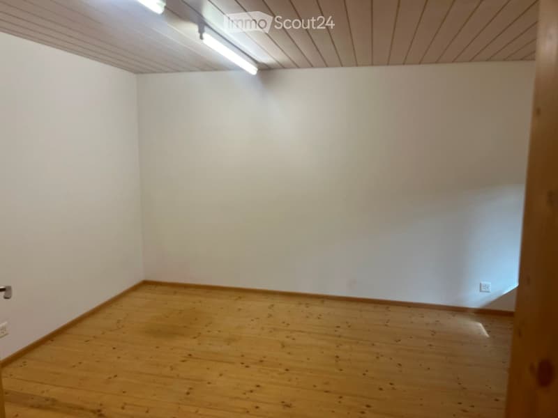 Empty room with wooden flooring and white walls, featuring a simple ceiling with recessed lighting.