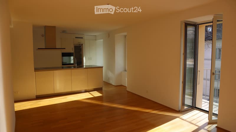 Open kitchen, wooden floor, sliding glass door to balcony, white cabinets, modern appliances