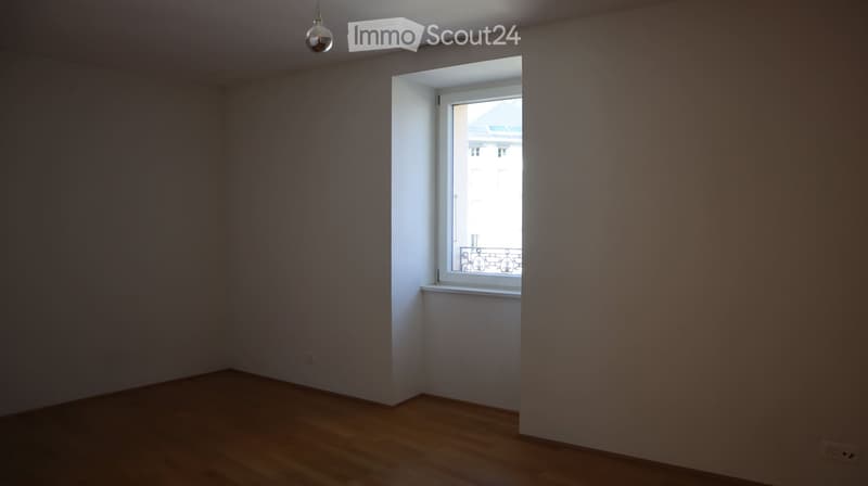 empty room, wooden floor, white walls, window with balcony, power outlet