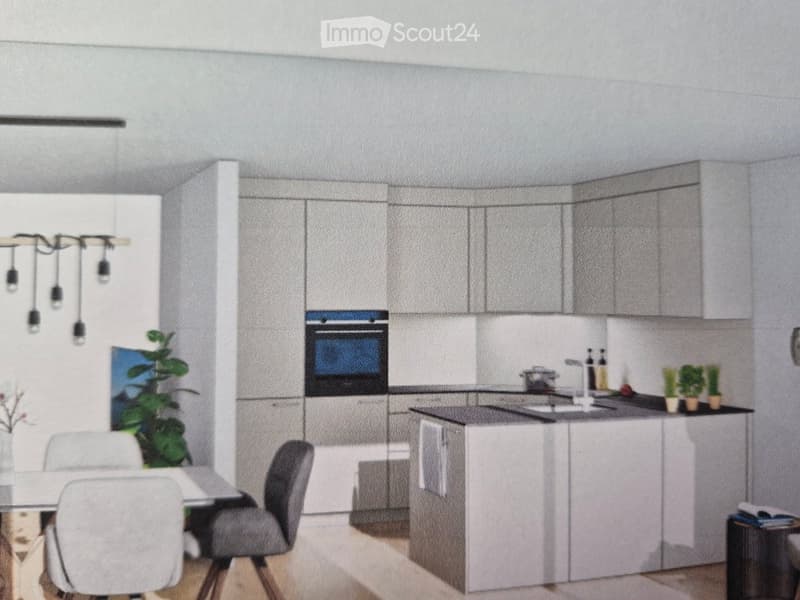 Modern kitchen with grey cabinets, island, dining area, and small potted plants on the counter.
