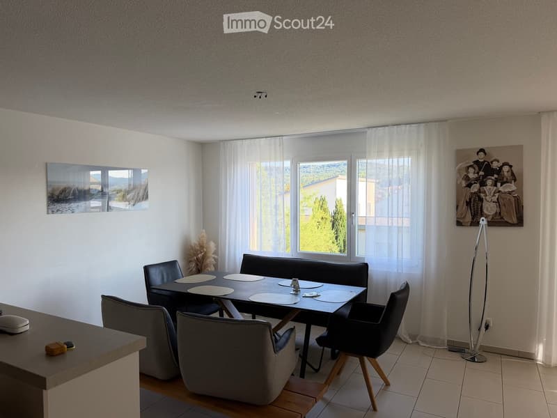 Modern dining area with a black dining table, grey chairs, a black sofa, and a floor lamp near the window.