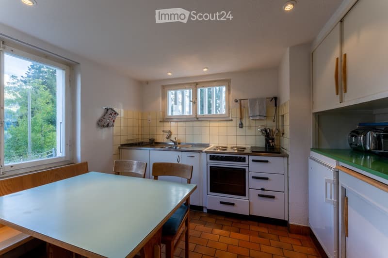 kitchen with white cabinets, table, chairs, oven, stove, sink, window, view of the outside