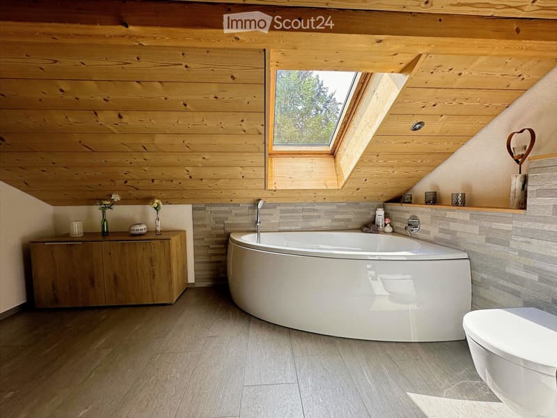 Modern bathroom with wooden walls and ceiling, large bathtub, toilet, wooden cabinet, and decorative vases.