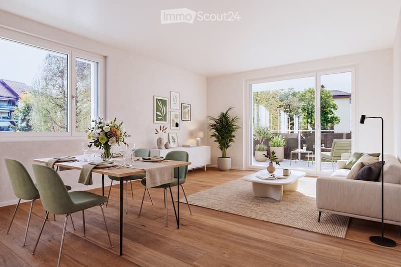 Bright, open living and dining area with wooden flooring, large windows, and a view of greenery. Features a cream sofa, coffee table, dining table with chairs, and decorative vases.