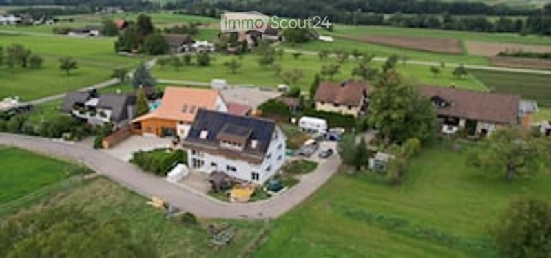 House complex with several buildings, swimming pool, green landscape, driveway, large garden