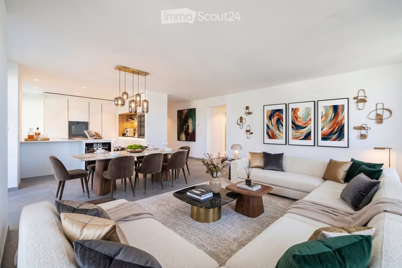 Modern open-concept living and dining area with a white sectional sofa, coffee table, dining table with chairs, and a small kitchen area with cabinets and appliances.