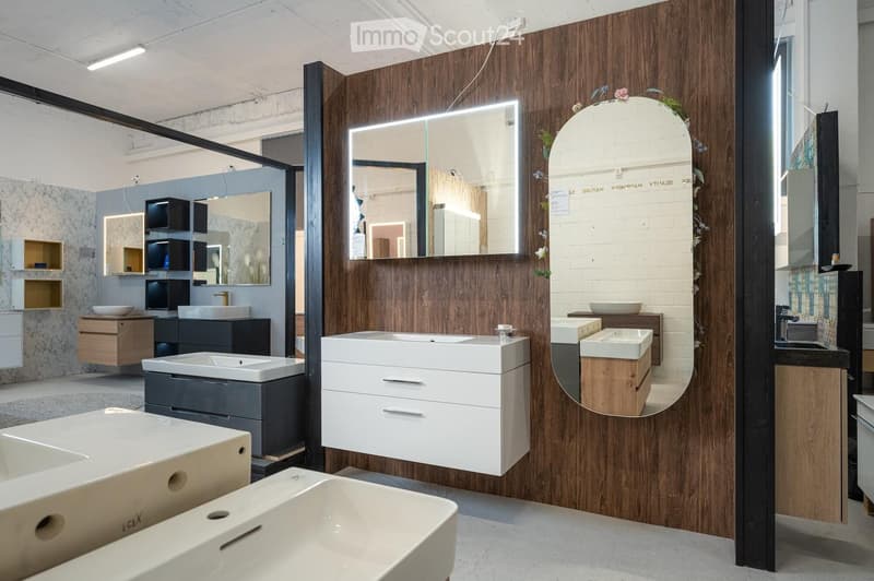 Modern bathroom display with various sinks, cabinets, and mirrors arranged in a showroom setting.