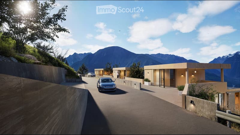 Modern house with a flat roof and large windows, situated on a raised ground floor with a parking area and a scenic mountain view in the background.