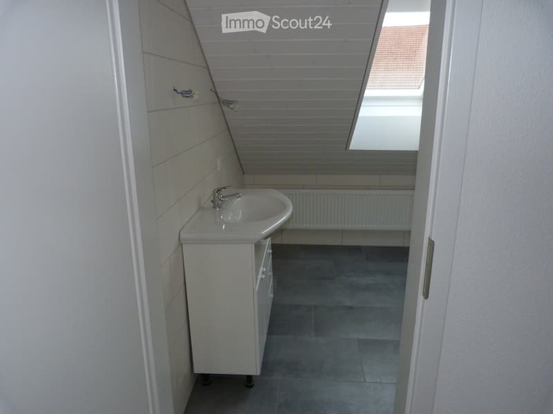 white floor and walls, sink with faucet, open doorway, skylight