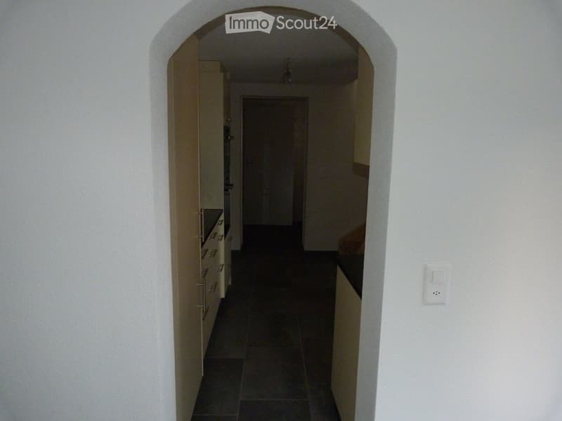 white walls, wooden arch, white kitchen cabinets, electrical switch