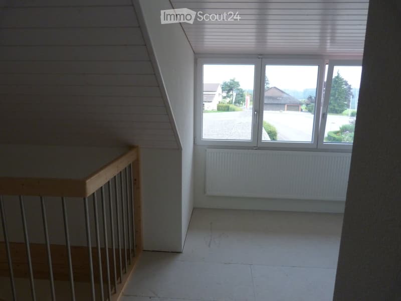 empty room, wooden railing, white walls, glass window, white radiator, tile floor