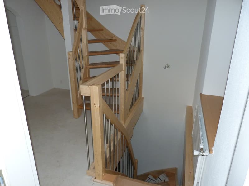 spiral wooden staircase, metal handrail, wooden steps, white walls