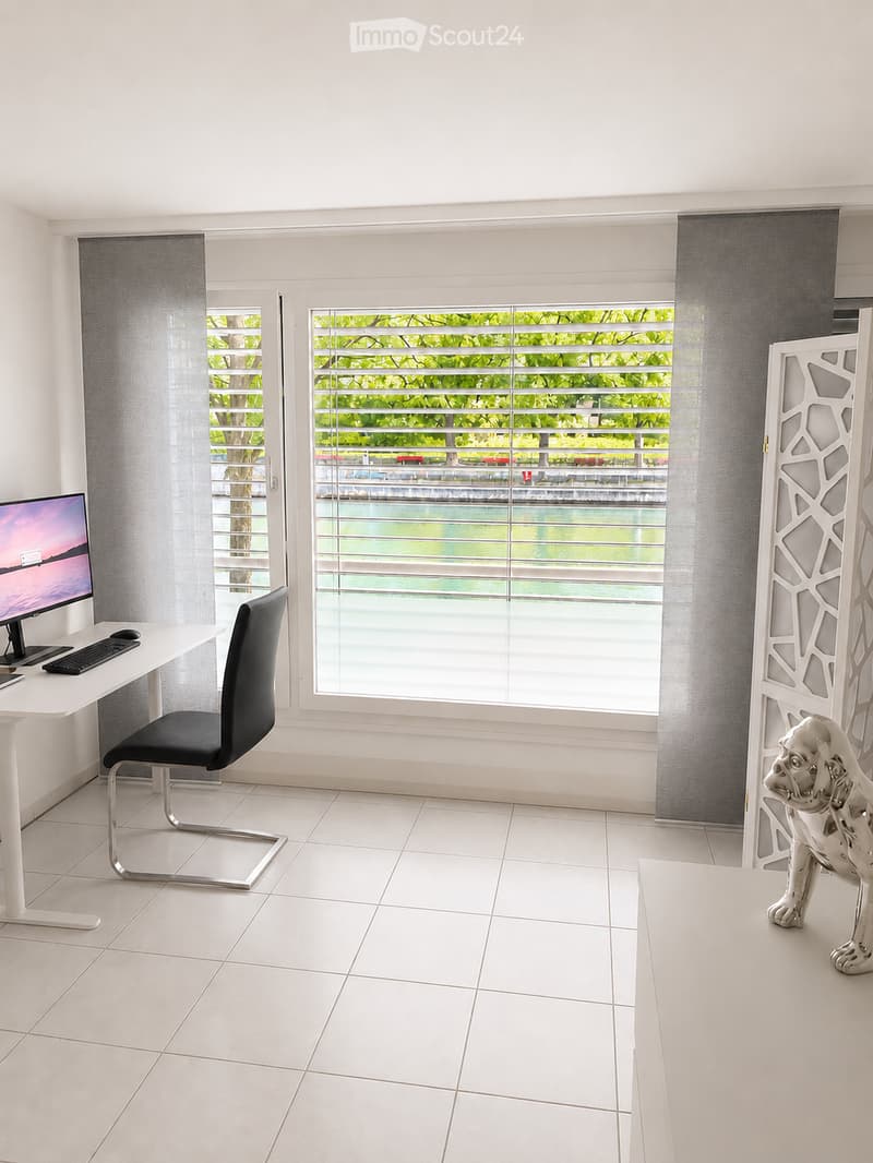 Modern, well-lit room with white tiled flooring, large windows with blinds, a white desk with a computer setup, a black office chair, and a decorative silver dog statue.
