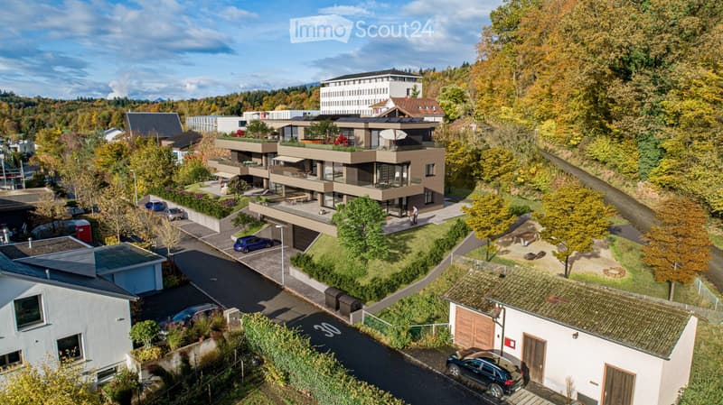 Modern multi-story apartment building with terraces, parking, and view