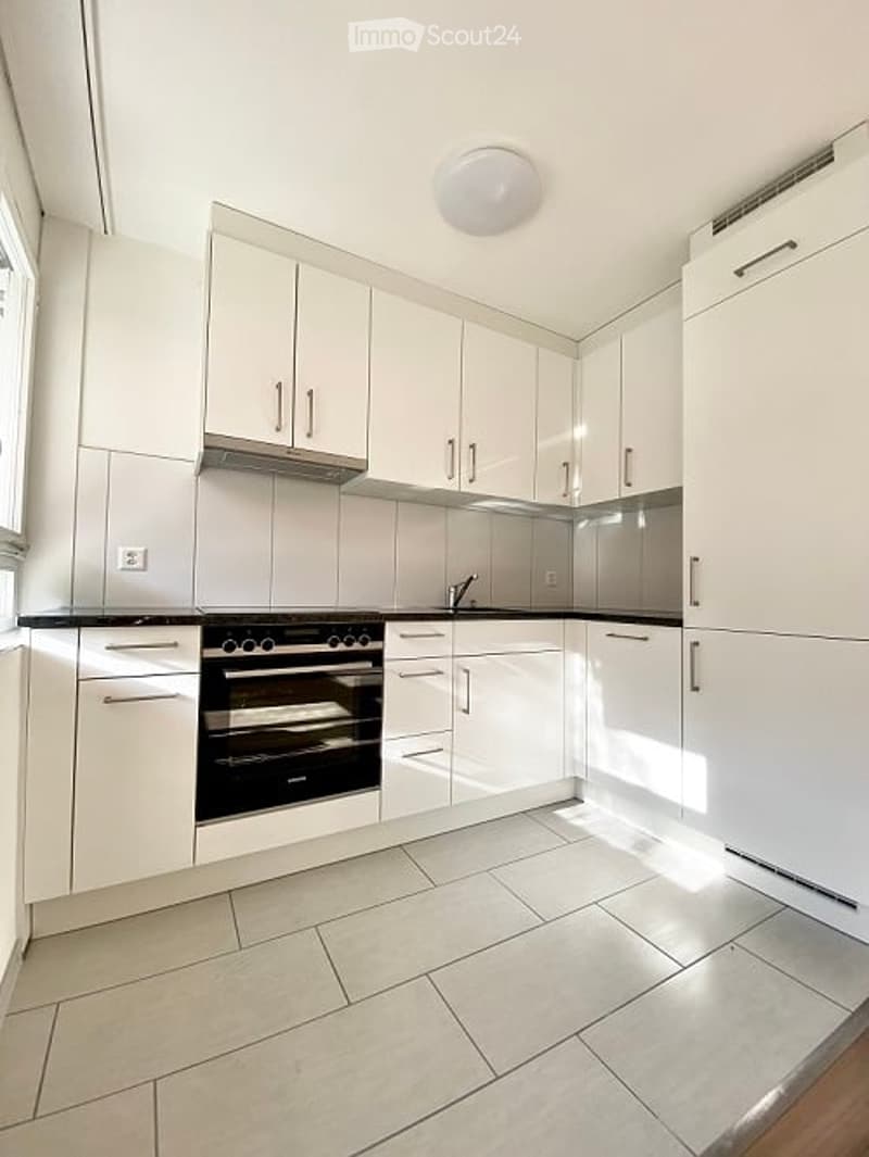 Modern kitchen with white cabinets, stainless steel appliances, and a clean, minimalist design.