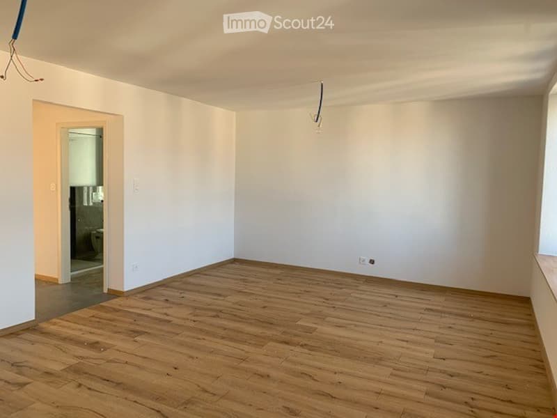 Completely empty room with bare white walls and wooden floor. No furniture or equipment.
