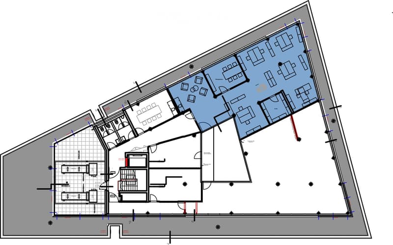 Floor plan of a multi-story building with multiple rooms, including offices, meeting rooms, and a large open area. The layout includes a staircase, several bathrooms, and a central corridor.