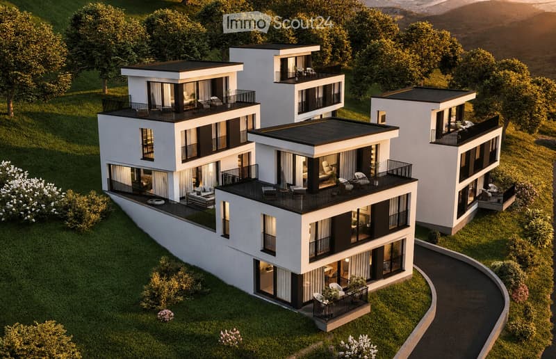 Aerial view of a modern, multi-story residential complex with white and black exterior, featuring balconies, large windows, and a landscaped garden area.
