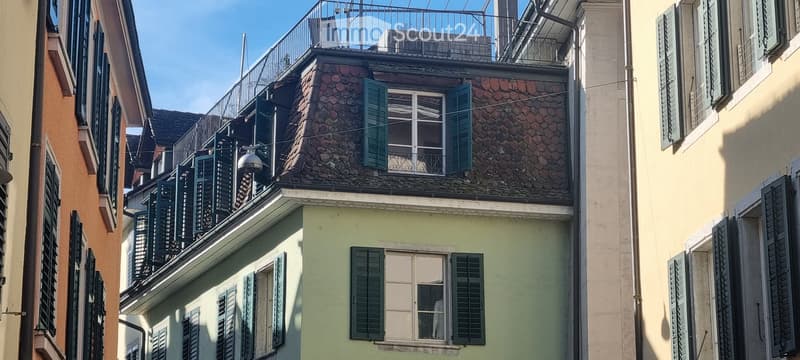 3-story house, stone roof, green shutters, balcony