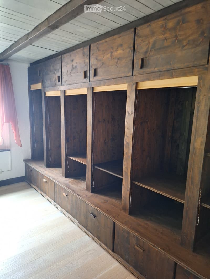 A large wooden cabinet with multiple shelves and drawers, featuring a rustic design and ample storage space.