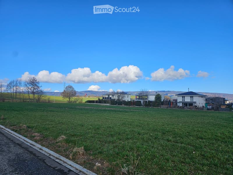 Plot of land for building a house, surrounded by fields and mountains