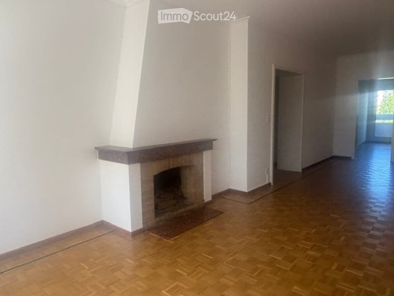 Empty room with wooden flooring and a fireplace against one wall. The space is unfurnished, with no visible furniture or equipment.
