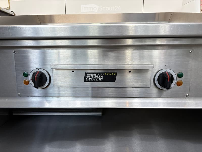 Stainless steel oven with control knobs and indicator lights, featuring a 'MENU SYSTEM' label.