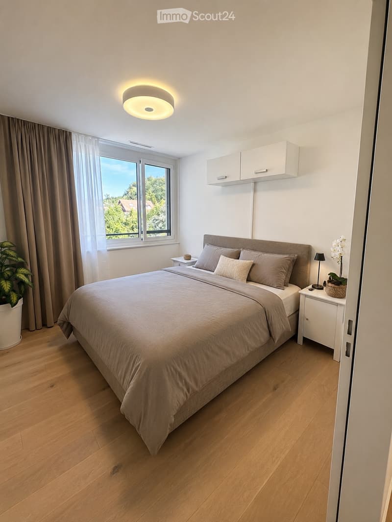 Modern bedroom with a large bed, nightstands, a lamp, built-in cabinets, and a large window with curtains. The room features wooden flooring and a potted plant near the window.