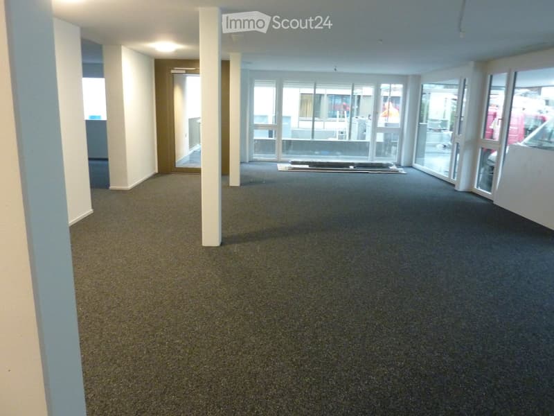 Empty room with carpeted floor, white walls, and large glass doors leading outside.