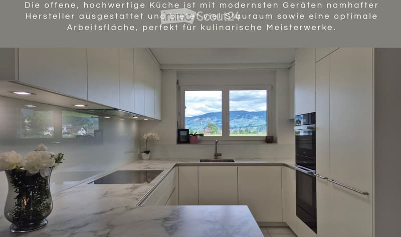 Modern kitchen with white cabinets, marble countertops, and large windows overlooking a scenic landscape.