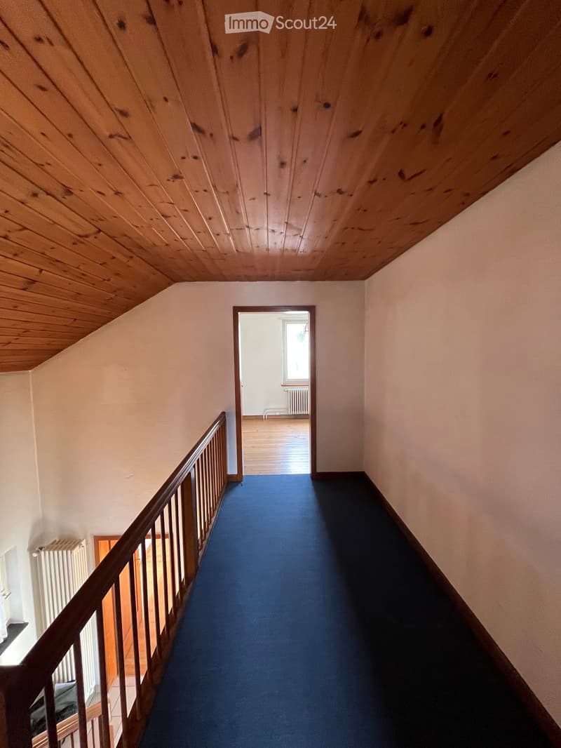staircase in the house with wooden handrail, blue carpet, wooden ceiling, white walls