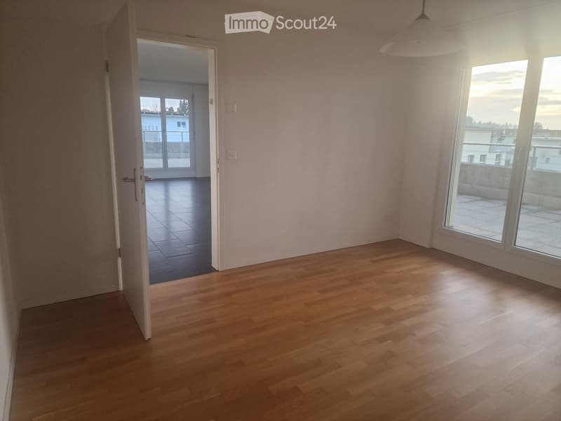 empty room with wooden floor, white walls, glass doors to balcony, windows, ceiling lamp