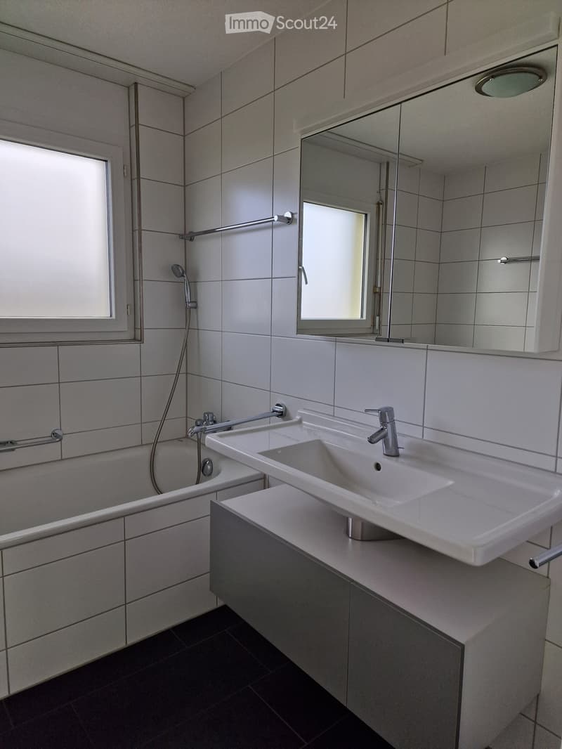 Bathtub, sink, mirror, tile walls, white bathroom fixtures, shower head