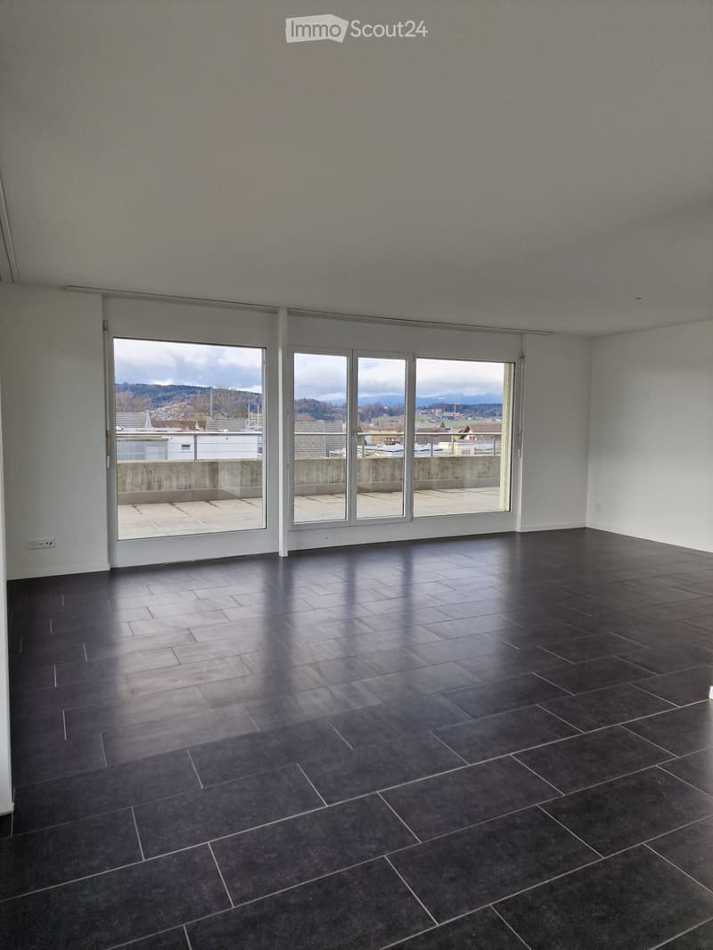 empty room with large windows, balcony, black tile floor, white walls