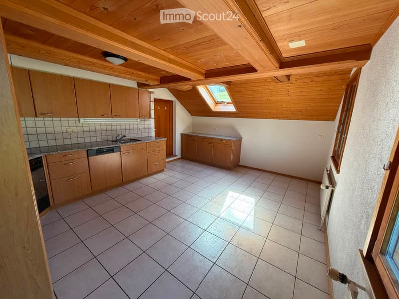 Bright kitchen with wooden cabinets, tiled floor, granite countertop, and a skylight window above the sink.