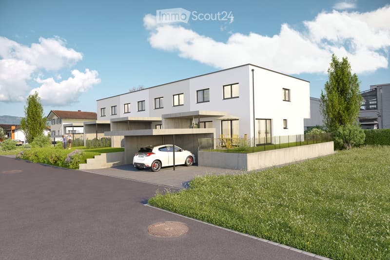 Modern two-story house with white exterior, large windows, and a raised ground floor. Features a covered parking area and outdoor seating area.