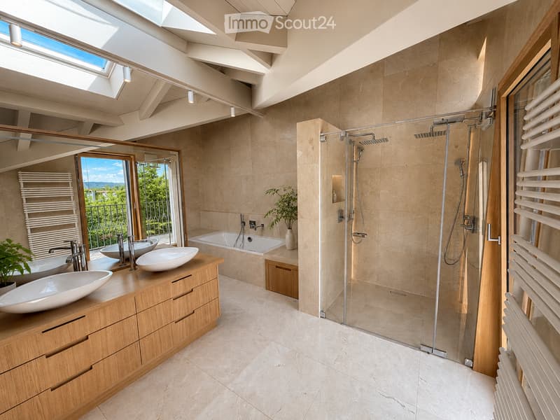 Modern bathroom with a large window offering a scenic view, featuring a double sink vanity, bathtub, walk-in shower, and a radiator.
