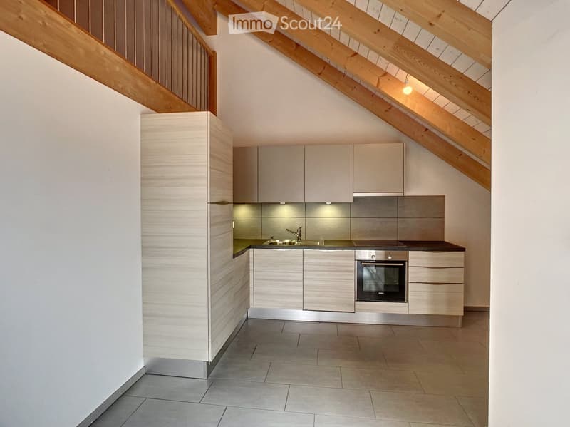 Modern kitchen with light wood cabinets, stainless steel appliances, and a sleek design, featuring an oven, sink, and faucet.
