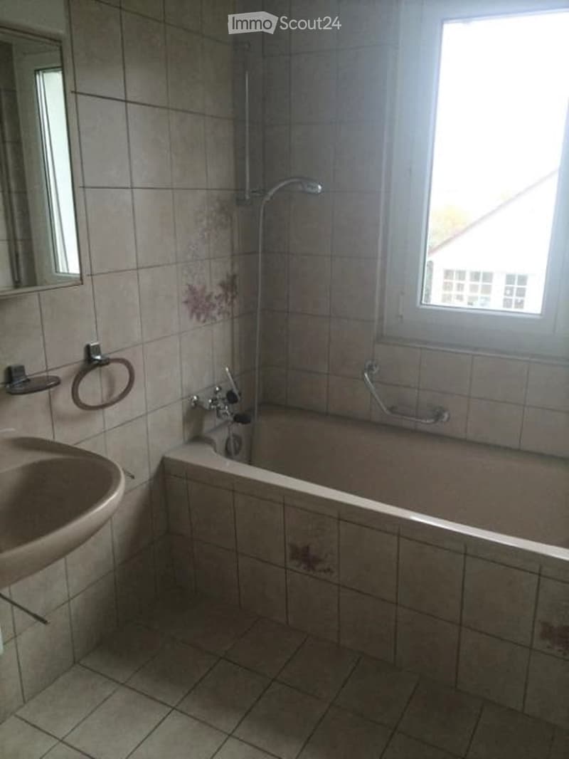 Bathroom with bathtub, sink, mirror, and window