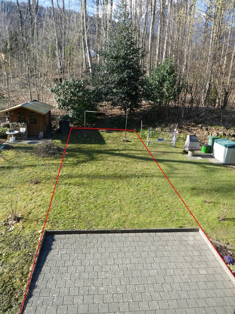 Outdoor garden area with a grassy lawn, a wooden shed, a small table, a barbecue, a hot tub, and a playground structure.