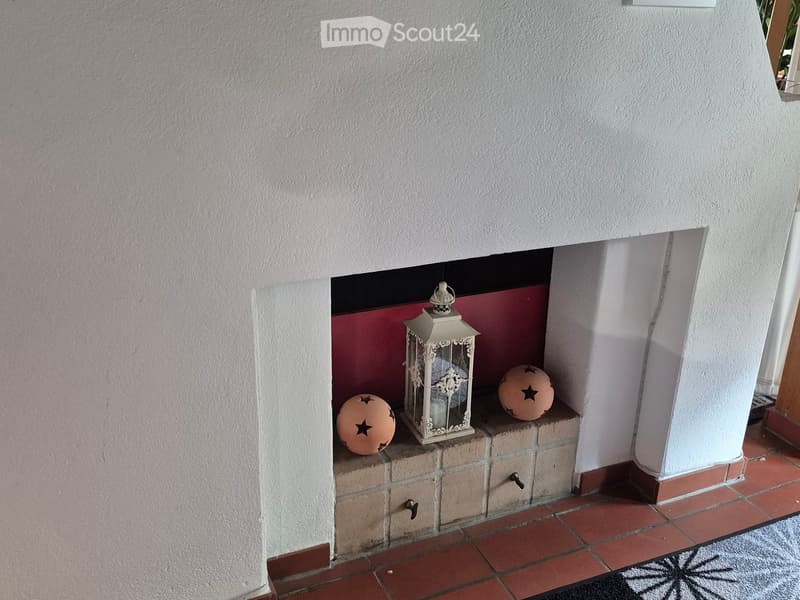 A small niche in a hallway with a decorative lantern and two spherical objects with star designs placed on a brick ledge.