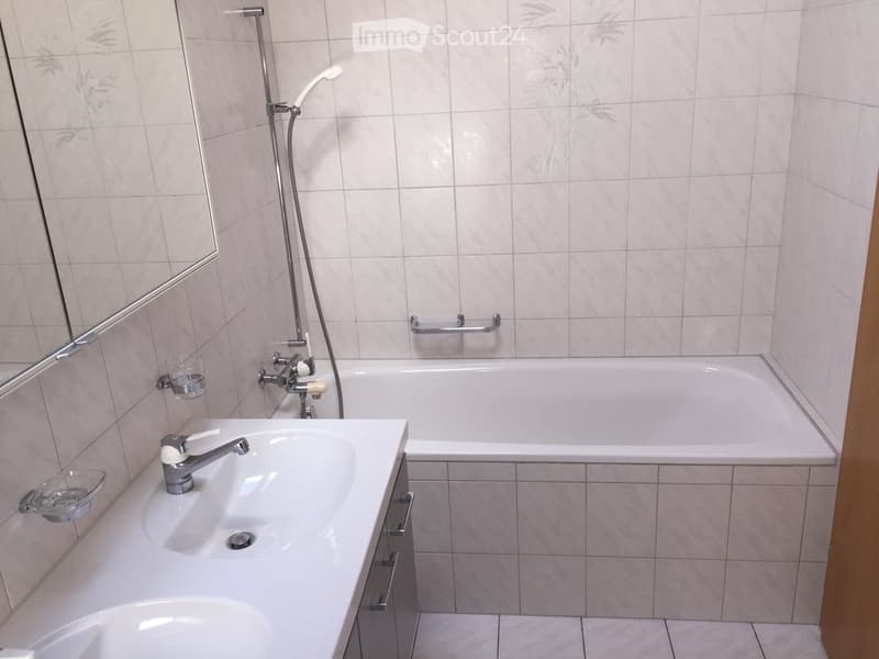 Bathroom with bathtub, sink, mirror, and shower head