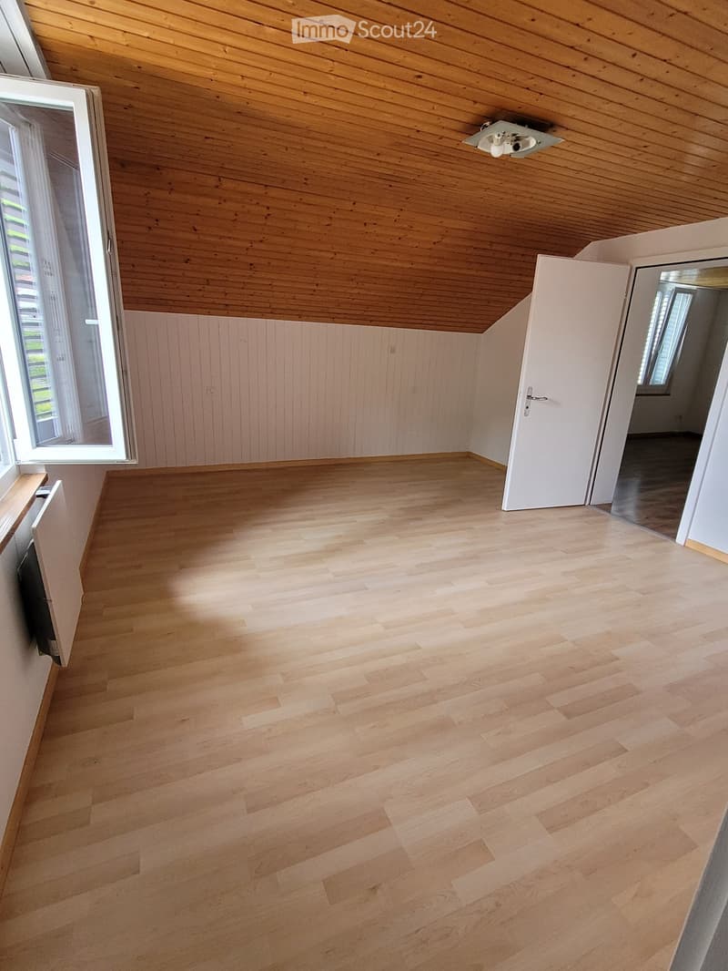 Empty room, wooden floor, white walls, wooden ceiling, open door, light fixtures, window with blinds