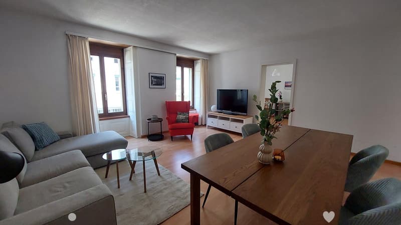 Dining room: table with chairs, living room visible in the background, TV, lamp