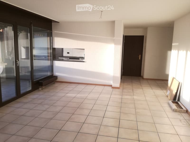 Empty hallway with tiled floor, white walls, large glass sliding door, and a closed door leading to another room.
